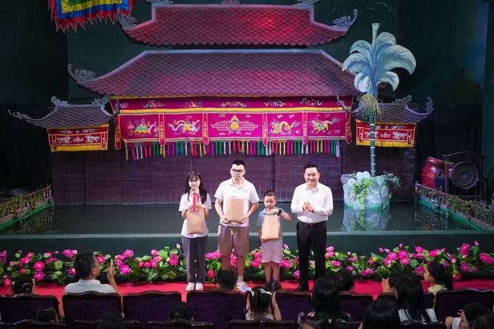 Đồng chí Phan Văn Hùng, Ủy viên Ban Thường vụ Đảng ủy, Phó Tổng Biên tập, Chủ tịch Liên chi hội Báo Nhân Dân trao phần thưởng tặng con cán bộ, công chức, viên chức, người lao động đạt thành tích trong học tập, năm học 2025-2026.