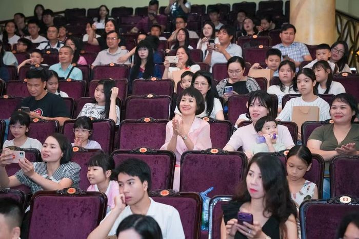 Các em học sinh cùng phụ huynh chăm chú theo dõi chương trình biểu diễn của các nghệ sĩ Nhà hát Múa rối Bông Sen.