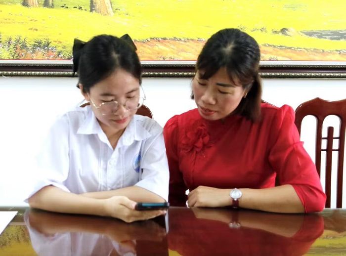 Trần Thị Bích Ngọc cùng cô giáo chủ nhiệm tra cứu điểm thi tốt nghiệp.
