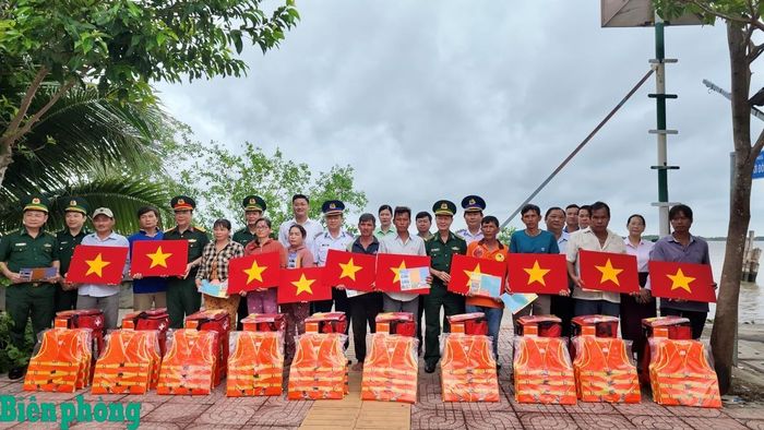 Ban tổ chức trao tặng cờ Tổ quốc, áo phao cá nhân, đèn pin, túi thuốc y tế cùng nhiều tài liệu tuyên truyền pháp luật cho ngư dân. Ảnh: Quang Tiến