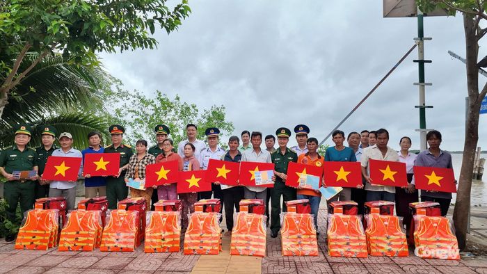 Trao tặng cờ Tổ quốc, áo phao cá nhân, đèn pin, túi thuốc y tế cùng nhiều tài liệu tuyên truyền pháp luật cho ngư dân.