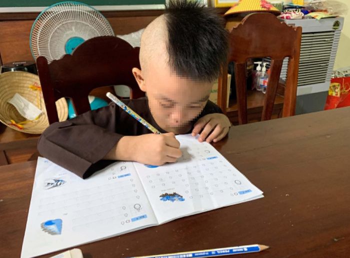 Bé trai được nhà chùa chăm sóc, sắm sách vở tập viết với nguyện vọng nhận nuôi lâu dài. Ảnh: Quang Hưng