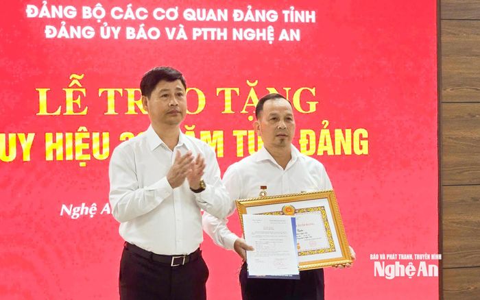 Đồng chí Trần Minh Ngọc - Ủy viên Ban Chấp hành Đảng bộ tỉnh, Bí thư Đảng ủy, Giám đốc Báo và phát thanh, truyền hình Nghệ An đã trao Huy hiệu 30 năm tuổi Đảng cho đồng chí Lê Công Tuấn.