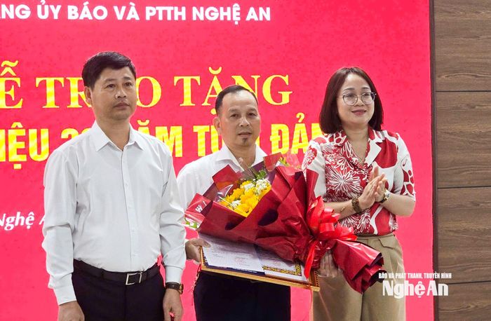 Đại diện Đảng ủy, Ban Giám đốc Báo và phát thanh, truyền hình Nghệ An tặng hoa chúc mừng đồng chí Lê Công Tuấn.