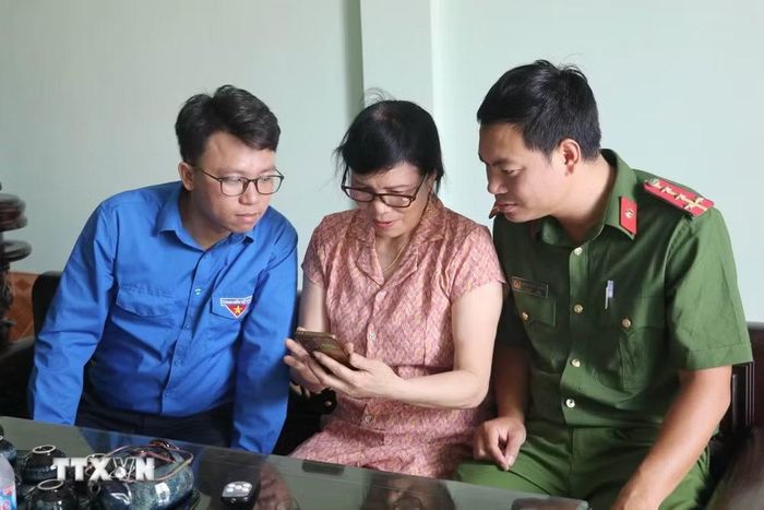 Lực lượng công an cùng với đoàn viên thanh niên hỗ trợ người dân tiếp cận các nền tảng số tại xã Giao Bình, tỉnh Ninh Bình. (Ảnh: Thùy Dung/TTXVN)