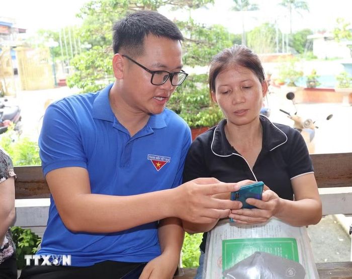 Đoàn viên thanh niên trực tiếp hỗ trợ người dân xã Giao Bình, tỉnh Ninh Bình nâng cao kỹ năng số. (Ảnh: Thùy Dung/TTXVN)