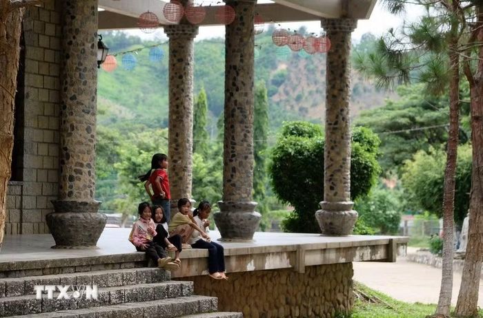 Nhà thờ Đạ Tông mở cửa tự do cho khách tham quan, cho các em nhỏ người địa phương đến vui chơi trong không gian rộng rãi, xanh mát giữa mùa hè. (Ảnh: Nguyễn Dũng/TTXVN)