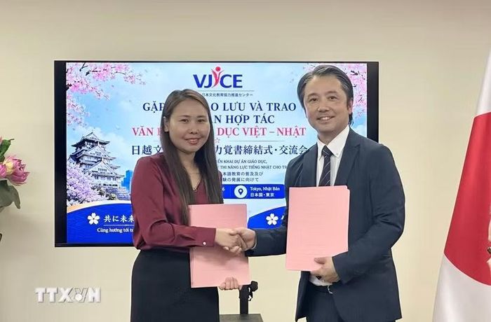 Đại diện VJCE và đại diện Trường tiếng Nhật Aoyama trao thỏa thuận ký kết. (Ảnh: Nguyễn Tuyến/TTXVN)