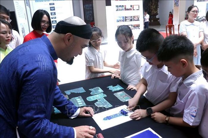 Học sinh hào hứng tham gia hoạt động trải nghiệm in dập hoa văn di sản tại không gian trưng bày.