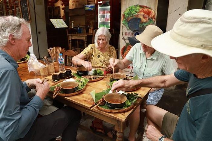 Du khách quốc tế trải nghiệm những đặc sản hấp dẫn của Hà Nội (Ảnh: Vân Chi).