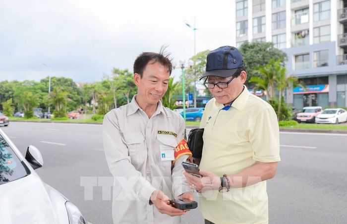 Khách hàng tại bãi trông giữ xe của Công ty CP Phát triển Uy Nguyên (phố Hội Xá, phường Phúc Lợi) cho biết, việc thu phí ETC thuận tiện và linh hoạt hơn nhiều so với phương thức thanh toán tiền mặt trước đây. Ảnh: Tiến Long/ TTXVN phát