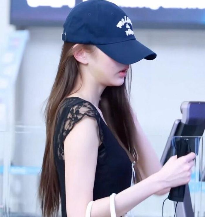 Jang Won Young đội mũ lưỡi trai kín đáo trong lúc làm thủ tục xuất nhập cảnh.
