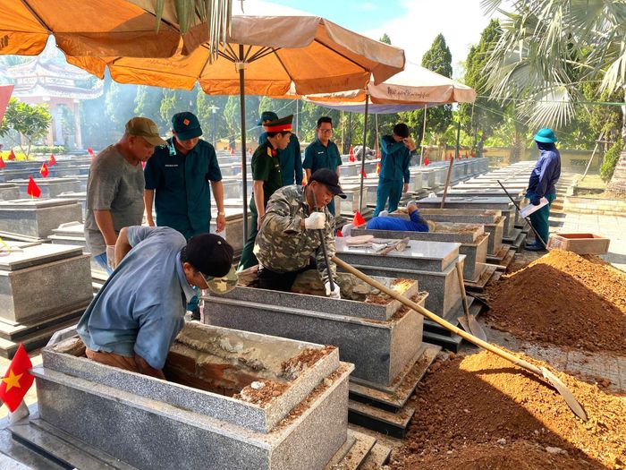 Các lực lượng xã Bà Nà thực hiện mở mộ, lấy mẫu hài cốt liệt sĩ chưa xác định thông tin để gửi giám định ADN nhằm trả lại tên tuổi, quê quán cho liệt sĩ. Ảnh: KIM PHƯỢNG