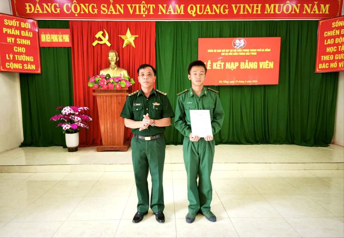 Trung tá Nguyễn Sỹ Danh, Chính trị viên Đồn Biên phòng Đắc Pring trao quyết định kết nạp đảng viên cho quần chúng Lê Viết Lợi. Ảnh: VĂN VINH