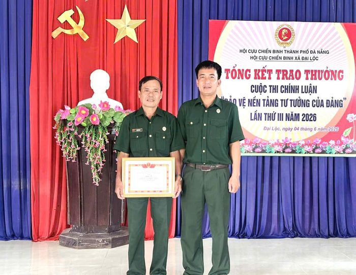 Chủ tịch Hội Cựu chiến binh xã Đại Lộc Huỳnh Minh Thủy (bên phải) trao thưởng cho hội viên có tác phẩm chính luận chất lượng. Ảnh: KHẢI KHIÊM