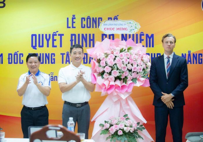Lãnh đạo Công ty Cổ phần thể thao SHB Đà Nẵng tặng hoa chúc mừng ông Joshua Edwin Shepherd (bên phải). Ảnh: THÀNH DANH
