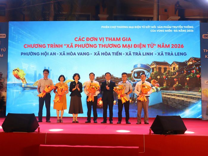 Ban tổ chức tặng hoa cho đại diện 5 xã, phường tham gia chương trình "Xã phường thương mại điện tử" năm 2026. Ảnh: QUỐC TUẤN