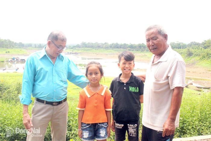 Ông Tuấn Cà Na (trái) và ông Ba Cọp (phải) thăm trẻ em làng bè tổ 10A, ấp Phú Ngọc 1. Ảnh: Ðoàn Phú