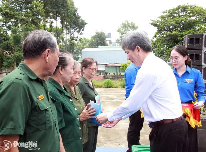 Thành ủy viên, Bí thư Đảng ủy phường Bình Long Bùi Quốc Bảo trao quà cho cựu thanh niên xung phong có hoàn cảnh khó khăn. Ảnh: Nga Sơn
