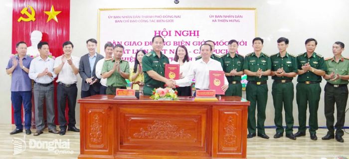 Đại diện Ban Chỉ đạo Công tác biên giới thành phố Đồng Nai và xã Thiện Hưng ký biên bản và bàn giao hồ sơ về hệ thống đường biên, mốc quốc giới cho xã Thiện Hưng. Ảnh: Thế Cường