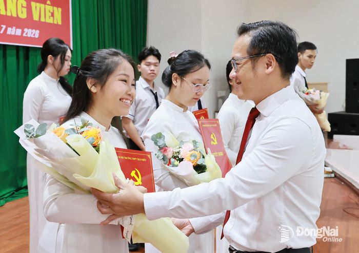 Bí thư Đảng ủy, Chủ tịch HĐND phường Tam Hiệp Nguyễn Xuân Thanh tặng hoa chúc mừng đảng viên mới. Ảnh: CN
