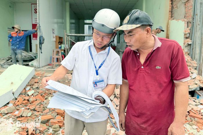 Cán bộ phường Trảng Dài vận động người dân bàn giao mặt bằng chuẩn bị khởi công đường Nguyễn Thái Học. Ảnh: Công Nghĩa