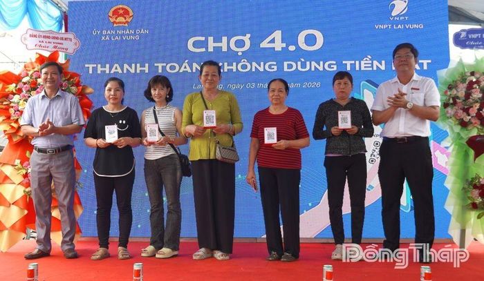 Đại diện lãnh đạo Đảng ủy xã Lai Vung và Agribank Lai Vung trao tặng mã QR cho tiểu thương kinh doanh tại chợ.