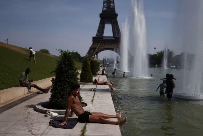 Người dân giải nhiệt tại khu vực tháp Eiffel. Ảnh: Reuters
