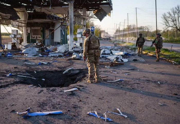 Hố bom gần một tòa nhà bị phá hủy ở khu vực Druzhkivka, tỉnh Donetsk, Ukraine. Ảnh: The Kyiv Independent