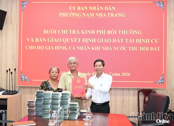 Chủ tịch UBND phường Nguyễn Văn Minh bàn giao quyết định giao đất tái định cư cho hộ ông Đặng Văn Sang.