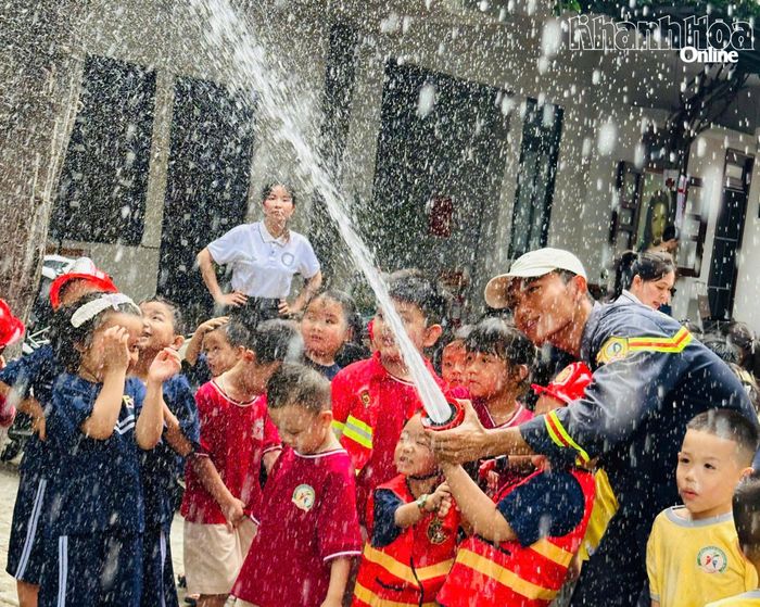 Học sinh hào hứng trải nghiệm thiết bị chữa cháy của các chiến sĩ.