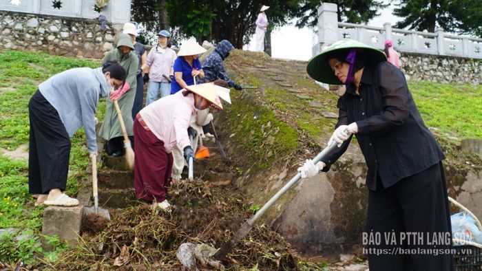 Cán bộ và người dân thu gom rác, nhổ cỏ tại hành lang bờ kè gần chân cầu Kỳ Cùng