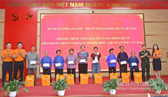 Các đại biểu trao quà hỗ trợ cho thân nhân gia đình liệt sĩ