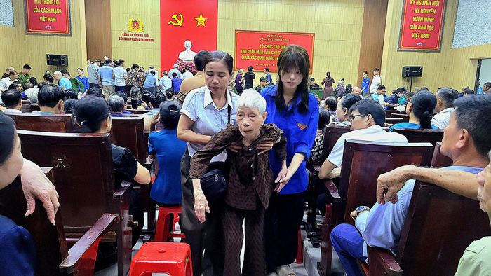 Các đoàn viên hỗ trợ thân nhân liệt sĩ già yếu làm các thủ tục lấy mẫu
