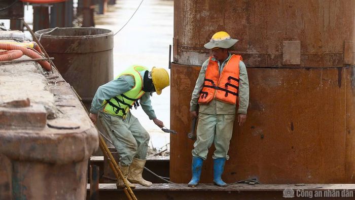 Cận cảnh công trình và công nhân đang thi công dự án đều được trang bị đầy đủ áo phao, phương tiện bảo hộ, thiết bị cứu sinh.