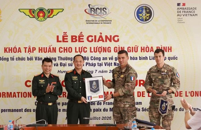 Hai chuyên gia thuộc lực lượng Hiến binh Pháp trao quà lưu niệm tặng cho Văn phòng Thường trực Bộ Công an về GGHB LHQ.
