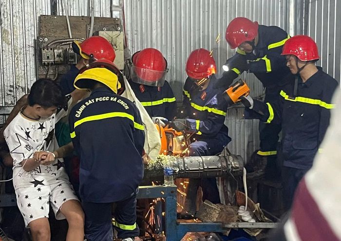 Lực lượng Cảnh sát PCCC và CNCH tìm mọi cách để cứu nạn nhân ra khỏi máy tái chế nhựa.