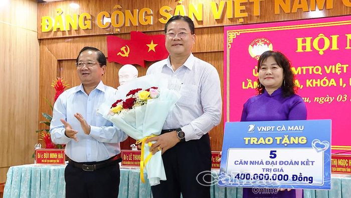 Dịp này, Ủy ban MTTQ Việt Nam tỉnh Cà Mau tiếp nhận nguồn hỗ trợ an sinh xã hội từ Viễn thông Cà Mau tặng 5 căn nhà Đại đoàn kết trị giá 400 triệu đồng. Trong ảnh: Ủy viên Ban Thường vụ Tỉnh ủy, Phó Chủ tịch Thường trực Ủy ban MTTQ Việt Nam tỉnh Cà Mau Lê Thanh Triều (bìa trái) tặng hoa cảm ơn đơn vị Viễn thông Cà Mau.