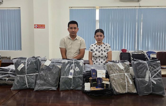 Nguyễn Đức Đạo và Phan Thị Hà Ly cùng tang vật làm giả nhãn hiệu thời trang nổi tiếng tại cơ quan điều tra.