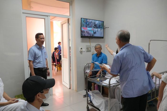 Phó Chủ tịch UBND phường Phú Diễn Chu Việt Dũng (người đứng góc trái) kiểm tra công tác khám sức khỏe cho người có công ngày 3-7. Ảnh: PV