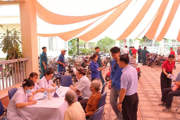 Lực lượng đoàn viên thanh niên và cán bộ phường hỗ trợ, hướng dẫn người có công làm thủ tục khám sức khỏe. Ảnh: PV