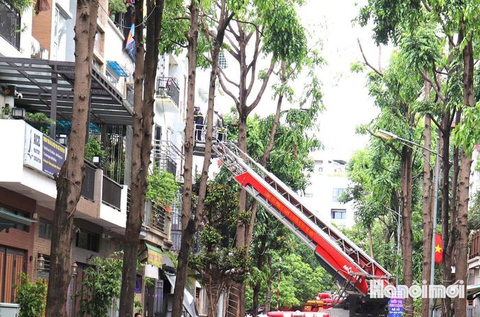 Lực lượng cứu nạn đưa nạn nhân từ tầng cao xuống bằng xe thang để chuyển đến bệnh viện cấp cứu. Ảnh: Tuấn Điệp