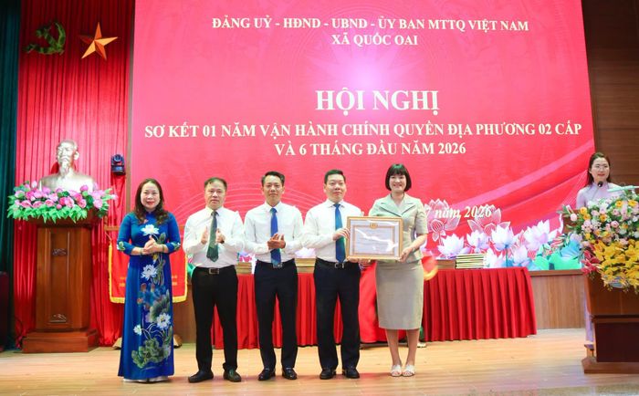 Đại diện Ban Thi đua - Khen thưởng Thành phố Hà Nội tặng Bằng khen của Ban Thường vụ Thành ủy Hà Nội cho Đảng bộ xã Quốc Oai vì có thành tích xuất sắc trong thực hiện nhiệm vụ năm 2025. Ảnh: PV