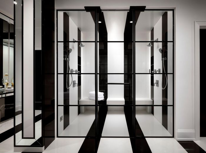 Phòng tắm chính có quy mô như một spa, với phòng tắm hơi mới xây, bồn rửa đôi, hệ tủ đặt riêng và bàn trang điểm. Không gian tiếp tục sử dụng họa tiết hình học trắng - đen, kết hợp gương, đèn tường và phụ kiện ánh vàng để đồng bộ với tinh thần sang trọng của toàn bộ căn nhà.