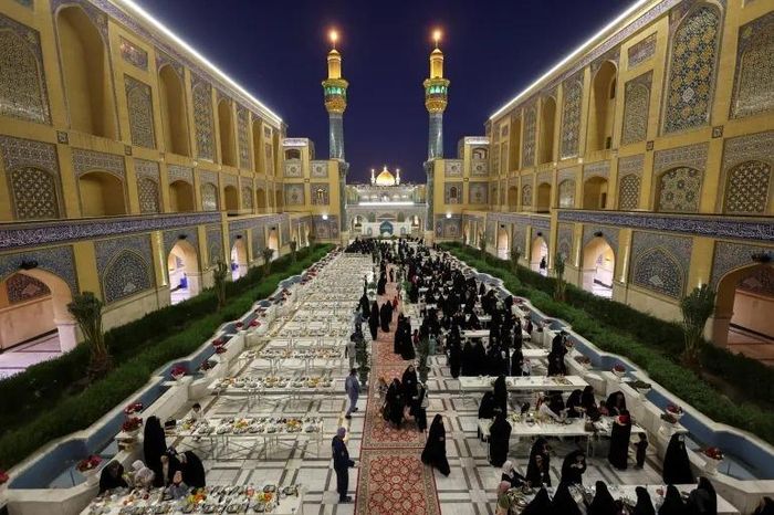 Những người hành hương tập trung tham dự bữa iftar công cộng miễn phí tại sân của đền thờ Imam Ali trong tháng Ramadan linh thiêng, ở Najaf (Iraq) ngày 20/2. Ảnh: Reuters.