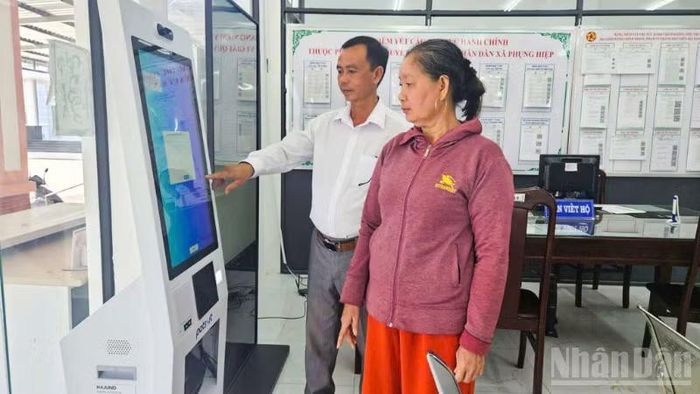 Ông Lê Hoàng Tân, Giám đốc Trung tâm Phục vụ hành chính công xã Phụng Hiệp hướng dẫn thao tác chuyển đổi số cho người dân.
