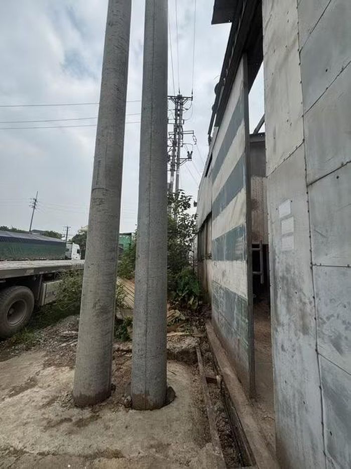 Cột điện dựng ngay sát cửa ra vào kho nông sản của người dân.