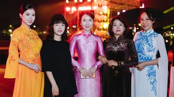 Nhà thiết kế Hồng Nhung (áo dài hồng) chụp ảnh lưu niệm cùng ê-kíp và những người bạn đồng hành tại Tuần lễ Áo dài Huế 2026.