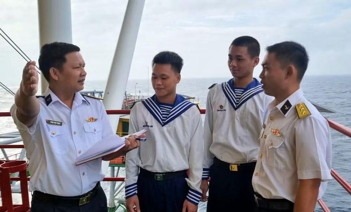 Chính trị viên nhà giàn DK1/14 (trái) hướng dẫn làm nhiệm vụ, nắm bắt tư tưởng của cán bộ, chiến sĩ.