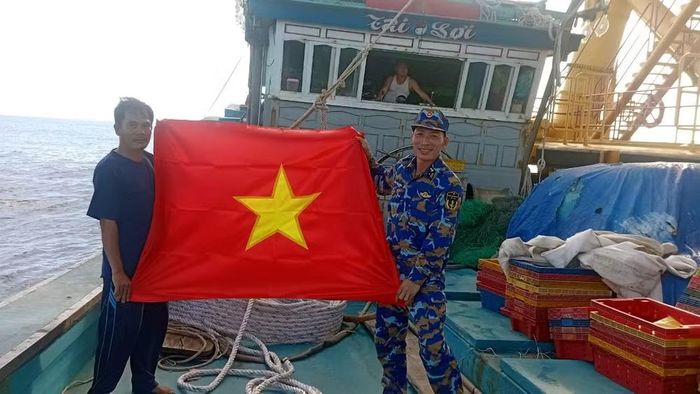 Bộ đội nhà giàn DK1 tặng cờ Tổ quốc cho ngư dân.